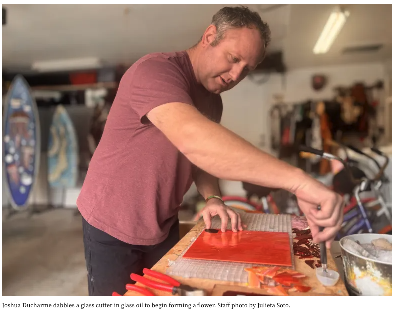 a male artist cutting glass and dipping oil