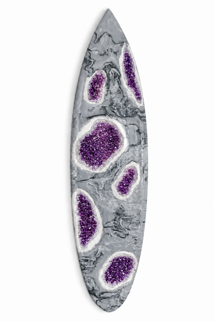 grey surfboard with amethyst stones embedded throughout.